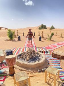 Un homme debout au milieu du désert dans l'établissement Sahara wellness camp, à Merzouga