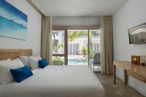 a bedroom with a bed and a view of the pool at The Beach House Resort in Gili Trawangan