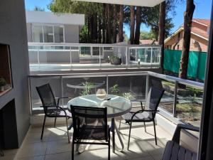 a patio with a table and chairs on a balcony at Departamento impecable ,complejo cerrado, asador y pileta in Villa Allende
