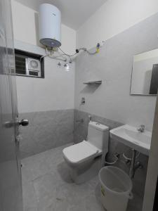 a bathroom with a toilet and a sink at Minimal Poshtel in Mysore