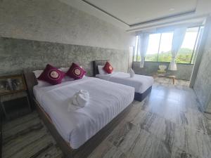 Habitación de hotel con 2 camas con almohadas rojas en 88 ลิฟวิ่ง โฮเทล ปากช่อง en Ban Sathani Bandai Ma