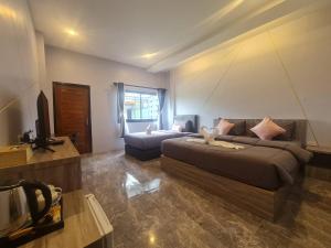 a bedroom with a bed and a couch in a room at 88 ลิฟวิ่ง โฮเทล ปากช่อง in Ban Sathani Bandai Ma