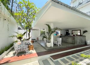 an outdoor patio with white furniture and plants at Calm Villa in Seminyak