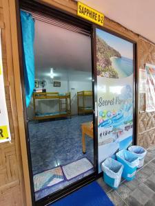 an open door of a beach house with a sign at CANIBAD SECRET PARADISE RESORT in Aumbay