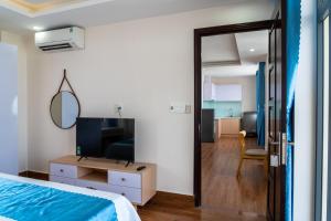 a bedroom with a bed and a tv and a mirror at Camellia Family Suites in Da Nang