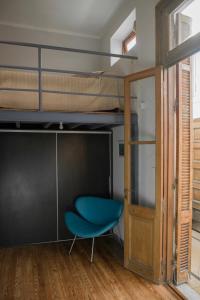 a room with a bunk bed and a blue chair at Departamento en San Telmo in Buenos Aires