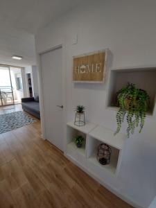 a living room with a plant on the wall at Apartamento en playa puig in Valencia