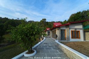 a house with a walkway in front of it at The Jungle Hook Binsar in Almora