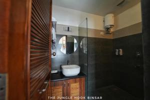 a bathroom with a sink and a mirror at The Jungle Hook Binsar in Almora