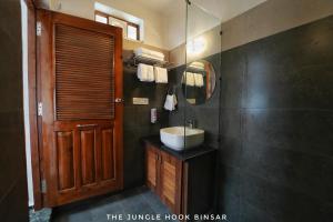 a bathroom with a sink and a mirror at The Jungle Hook Binsar in Almora