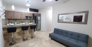 a living room with a couch and a kitchen at NCG SUITE SAMANES in Guayaquil