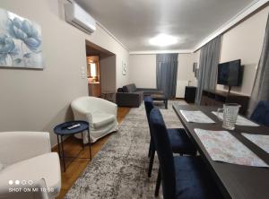 ein Wohnzimmer mit einem Tisch, Stühlen und einem Sofa in der Unterkunft Cozy apartment near the sea in Palaio Faliro in Athen