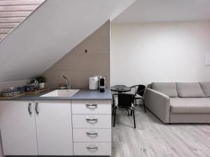 a kitchen with a sink and a couch in a room at מבט אל הואדי in Abū Ghaush