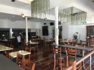 a dining room with tables and chairs and a bar at The Prince of Wales in Proserpine