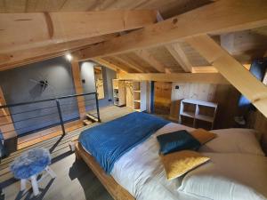 Cette chambre dispose d'un grand lit et de plafonds en bois. dans l'établissement Chalet cosy et moderne vue montagnes, à Seytroux
