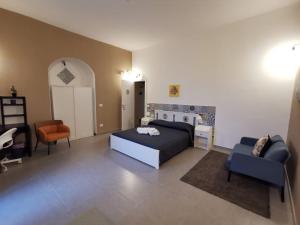 a bedroom with a bed and a couch and a chair at Hercules Suites in Noto