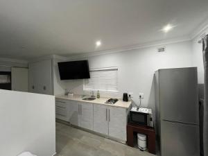 a kitchen with a refrigerator and a sink and a microwave at Guest house on Gillian Unit 6 in Ballito