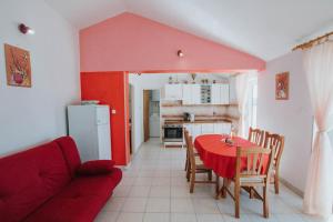 uma sala de estar com uma mesa e um sofá vermelho em Apartman Relax 2 em Zaboric