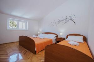 a bedroom with two beds and a window at Apartman Relax 2 in Zaboric
