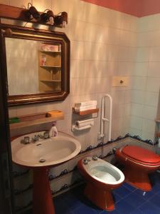 y baño con lavabo, aseo y espejo. en VILLA SECCHI, en Castrezatto
