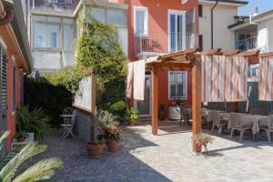 an outdoor patio with tables and chairs and plants at La corte dei tre in Torre del Lago Puccini