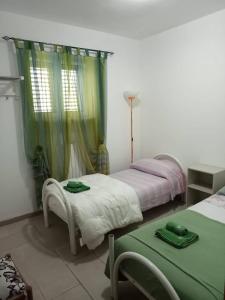 um quarto com 2 camas e uma mesa com lençóis verdes em Villa Gardenia em Ostuni