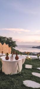 a white table with two vases on top of it at Nanti Villas Lombok in Kuta Lombok