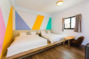 Duas camas num quarto com uma parede colorida em 澎湖金宿喜民宿Penghu Comfy B&B em Magong