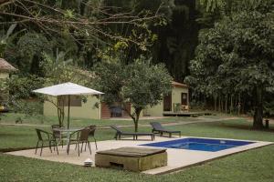 a patio with a table and chairs and an umbrella at La Frontera in Chinchiná