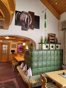 a restaurant with a green bench and tables and wine bottles at Hotel Obergfell in Todtnau