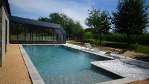 a swimming pool with two chairs and a building at La grange de Pachon in Aurice