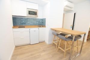 uma pequena cozinha com uma mesa de madeira e cadeiras em Hotel Mar Azul em A Lanzada