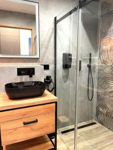 a bathroom with a shower with a sink at APARTAMENT ELEGANCE RED w Let's Sea Basen&SPA in Gąski