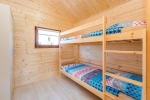 a bedroom with bunk beds in a wooden cabin at Pirat Gąski in Gąski