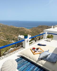 a table on a balcony with a view of the ocean at Serifos White in Serifos Chora