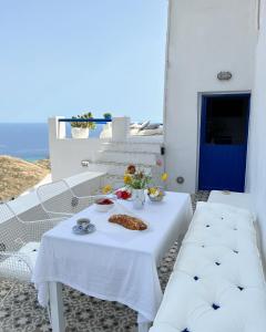 a white table with a plate of food on it at Serifos White in Serifos Chora