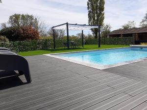 a swimming pool with a gazebo and a picnic table at Gite La Volière Ouverte in Valigny