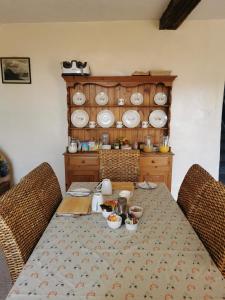 une table à manger avec des chaises et des assiettes sur un mur dans l'établissement Rainors farm B&B, à Gosforth