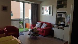 uma sala de estar com um sofá vermelho e um micro-ondas em Pleasant City Stay on Collins em Melbourne