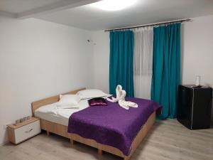 a bedroom with a bed with a stuffed animal on it at 3M Vila in 2 Mai