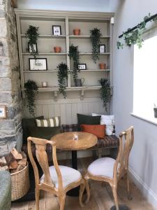 a table and two chairs and a couch in a room at The Farmhouse at Bodnant Welsh Food in Conwy