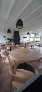 a dining room with wooden tables and chairs at Logis Auberge des Aulnettes in Houlgate