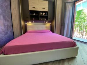 ein Schlafzimmer mit einem rosa Bett und einem Fenster in der Unterkunft La Casa del Poeta in Taormina