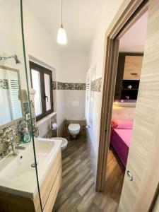ein Bad mit einem Waschbecken, einem WC und einem Bett in der Unterkunft La Casa del Poeta in Taormina