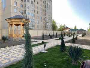 a garden with a gazebo in front of a building at Panjakent Plaza in Panjakent