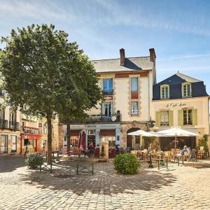 a large building with tables and umbrellas in front of it at * LE CHAMARELLE * Hyper Centre Auray * in Auray