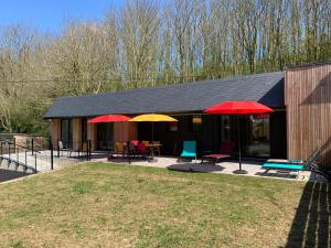 une maison avec deux parasols rouges et jaunes dans l'établissement LES GITES D'AULT. Meublé Le Hâble d'Ault., à Ault