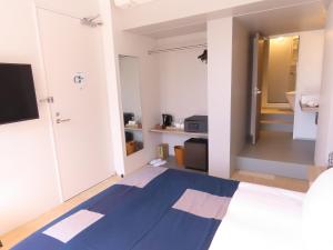 a bedroom with a blue and white bed and a bathroom at Osaka Hokko Marina HULL in Osaka