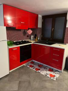 una cucina con armadi rossi e un pavimento con cuori rossi di Appartamentino sul lago di Bolsena a Gradoli