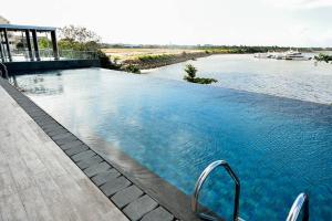 a large swimming pool next to a body of water at Lovina 16-AE at One Residence(near Ferry Terminal) in Batam Center